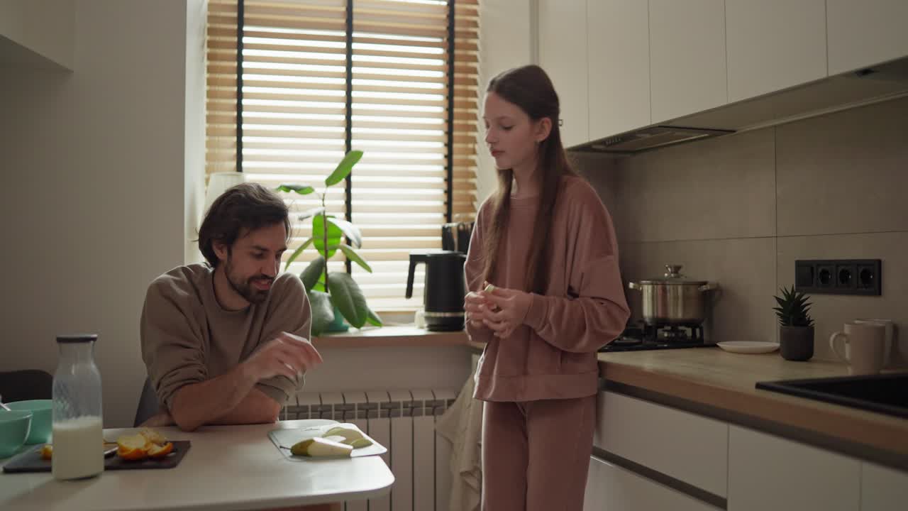 Father and daughter eating breakfast in the kitchen