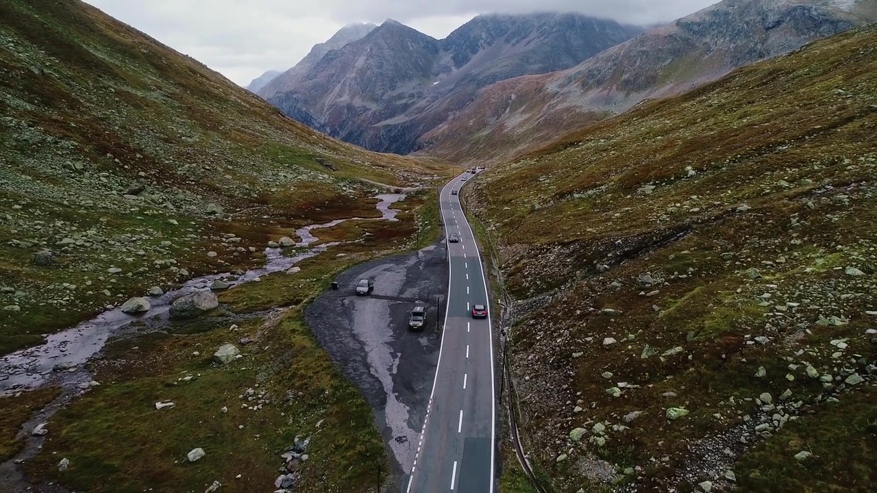 Prospettiva cinematografica di un'autostrada di montagna, Svizzera, cime aspre, luce soffusa