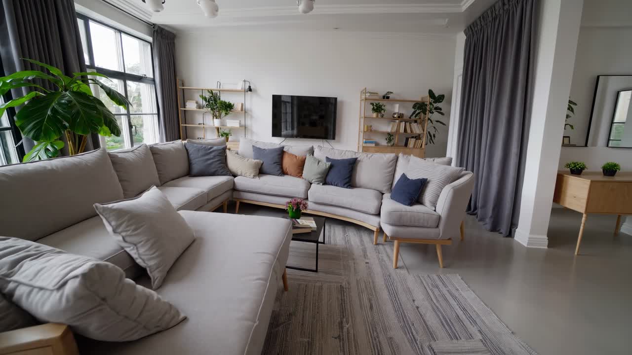 el diseño interior moderno muestra una sala de estar cómoda y elegante con un gran sofá curvo, una televisión de pantalla plana y una decoración minimalista, creando una atmósfera serena y acogedora.
