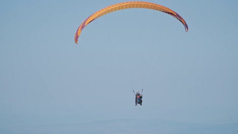 a stunning aerial scene featuring three paragliders soaring across an open sky. their vibrant purple, green, and red parachutes stand out.