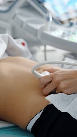 doctor moving sensor of ultrasound machine by the female belly. ultrasonic diagnostics on early stages of pregnancy. vertical video