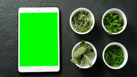 Various-herbs-with-digital-tablet-on-black-background-4k