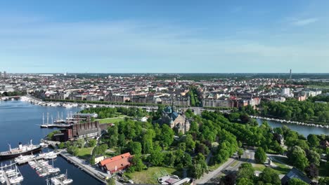 Beautiful-descending-aerial-showing-Nordiska-Nordic-museum-and-the-Djurgarden-island-in-swedens-capital-Stockholm---Ostermalm-and-Norra-Djurgarden-in-background