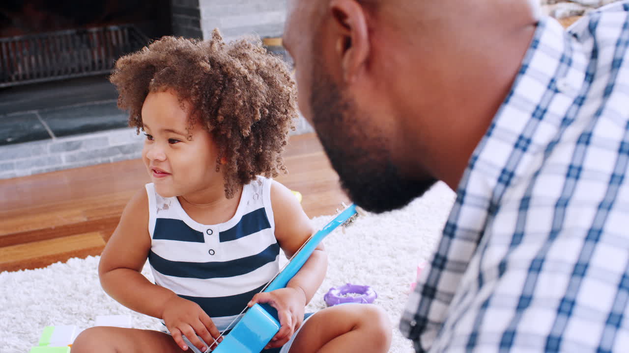 Young black girl playing ukulele and singing with her dad
