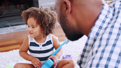 young black girl playing ukulele and singing with her dad