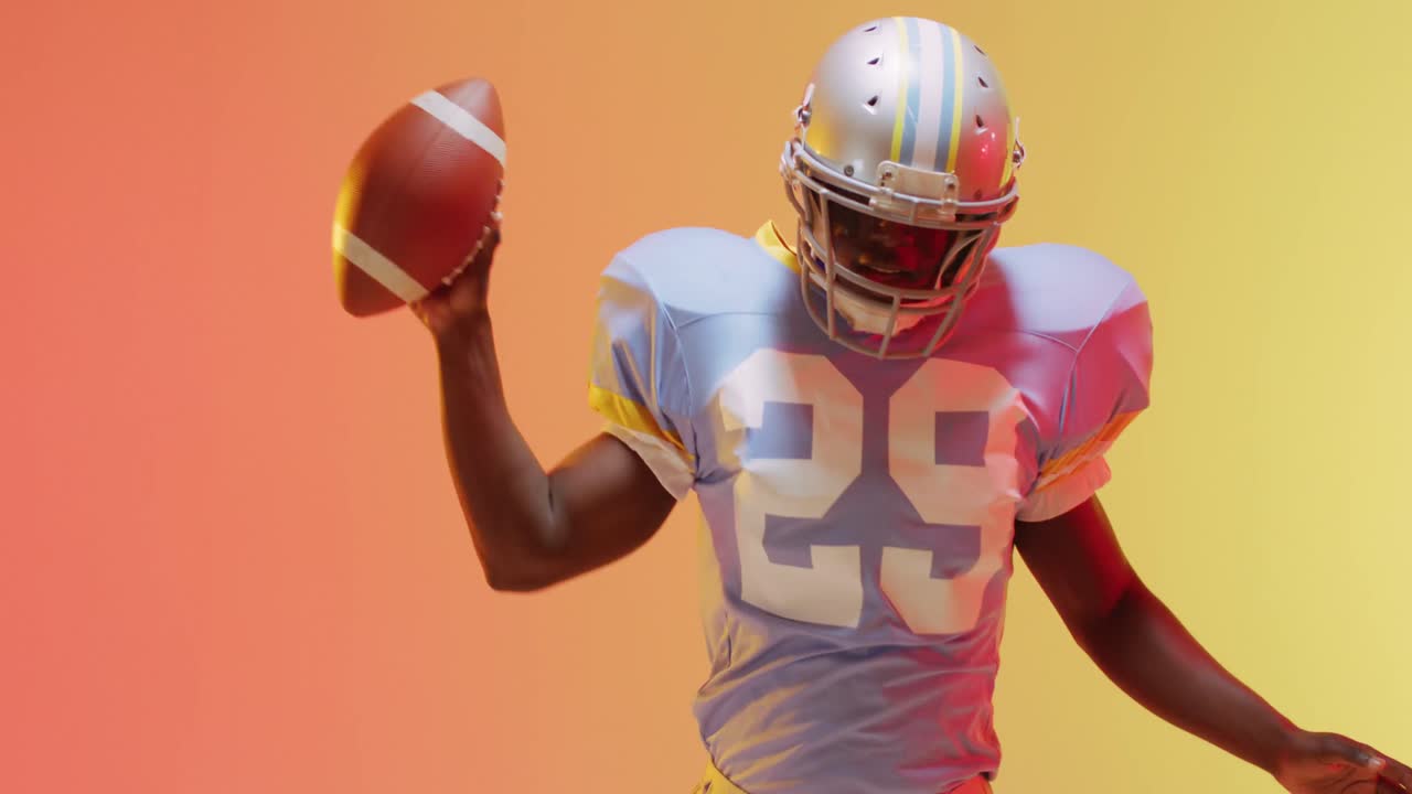 Video di un giocatore di football americano afroamericano con pallone su sfondo giallo-arancione.
