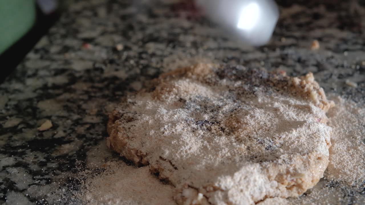 카운터 위에 사과와 양귀비 씨를 반죽에 밀가루를 뿌리는 여자