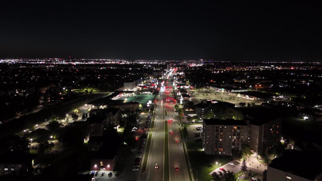 Ripresa aerea notturna ad alta quota con drone in volo sopra la Pembina Highway, che mostra le luci della città e il traffico urbano a Winnipeg, Manitoba, Canada