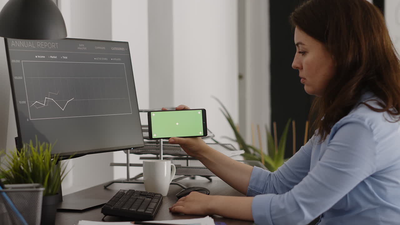 Businesswoman analyzing data on computer and smartphone