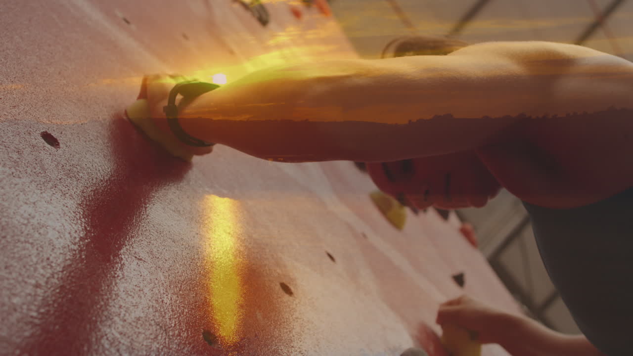 Animation of sunset over caucasian woman climbing wall