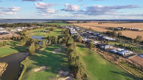 über-Golfplatz-Und-Fairways-Und-Neben-Neuen-Häusern-Den-See-Und-Das-Ackerland-Dahinter