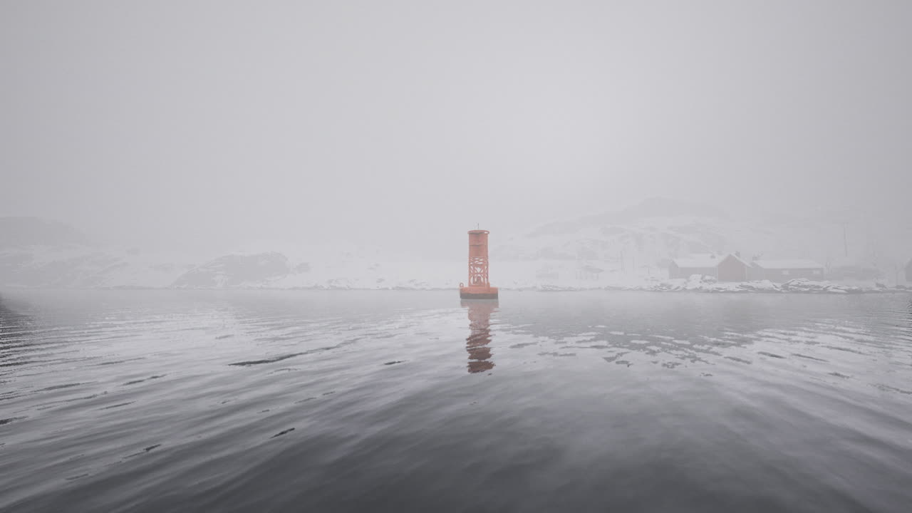 Foggy winter landscape with a single buoy in a serene icy water