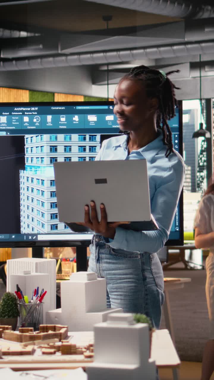 Vertical Video Black real estate engineer works with 3D towers and digital blueprints