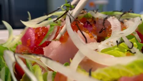 Ensalada-De-Sashimi-Con-Atún,-Cola-Amarilla-Y-Salmón-Sobre-Una-Cama-De-Lechuga-Y-Cebolla