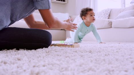 Joven-Negra-Jugando-Con-Un-Niño-Gateando,-ángulo-Bajo