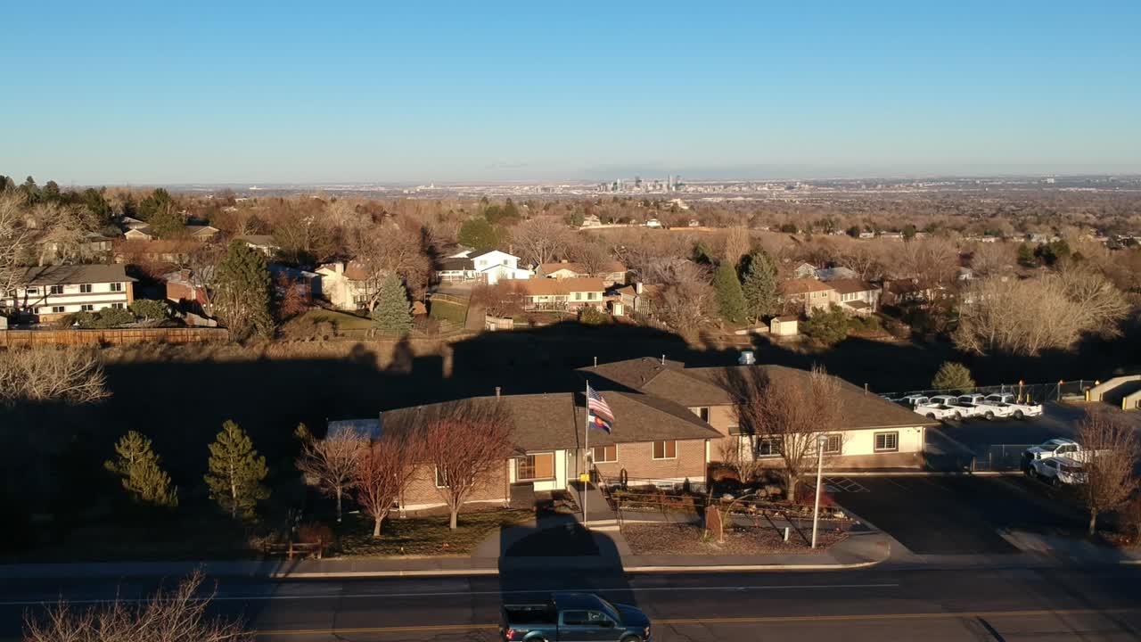 덴버가 수평선에 나타날 때 콜로라도 일몰 동안 바람에 깃발이 흔들립니다.