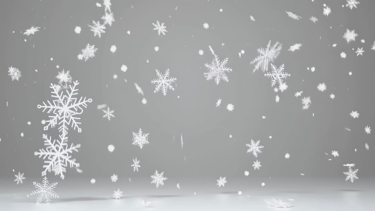 Video of falling snowflakes against a gray background, captured from a straight-on angle