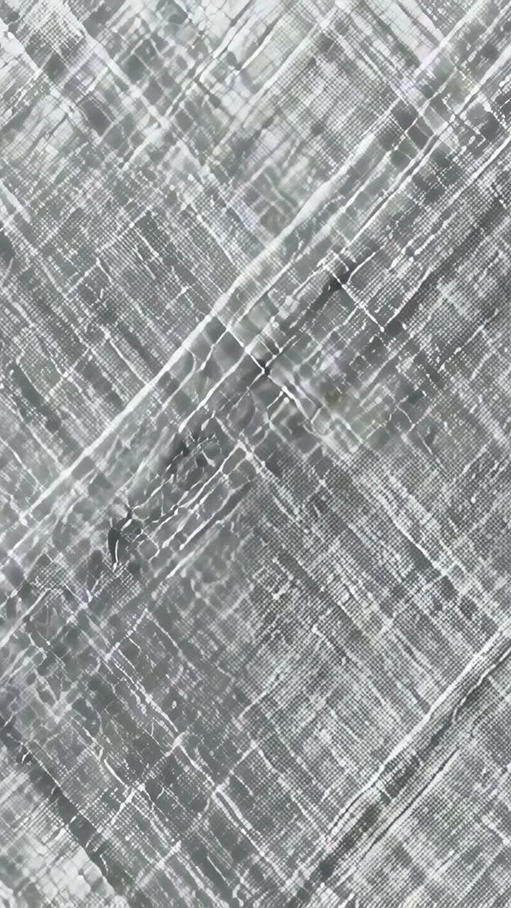 Vertical video: Recording macro lens shifting focus on grey lattice, revealing texture pattern