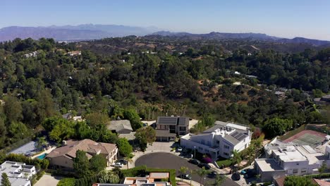 Reverse-aerial-shot-of-a-Sherman-Oaks-neighborhood-in-the-hills-with-Downtown-Los-Angeles-in-the-far-distance