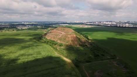 household waste landfill. closed for processing. environment protection. close-up shot. the city is visible on the horizon. aerial photography