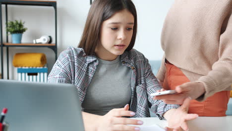 teenage girl doing homework with her mother