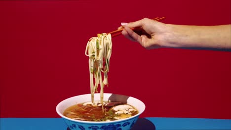 una mujer comiendo sopa de ramen.