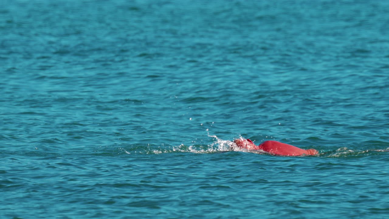 Man swimming freestyle in the calm turquoise water off the coast of Cannes, France