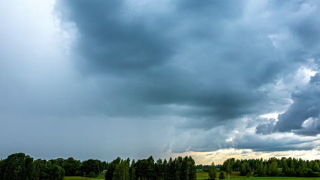 nubes oscuras se mueven sobre la naturaleza rural con árboles densos