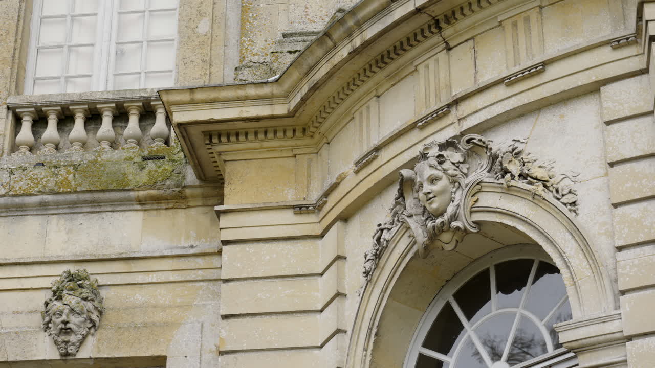 Ornate Stone Carving of a Mascaron on a Historic Building Facade
