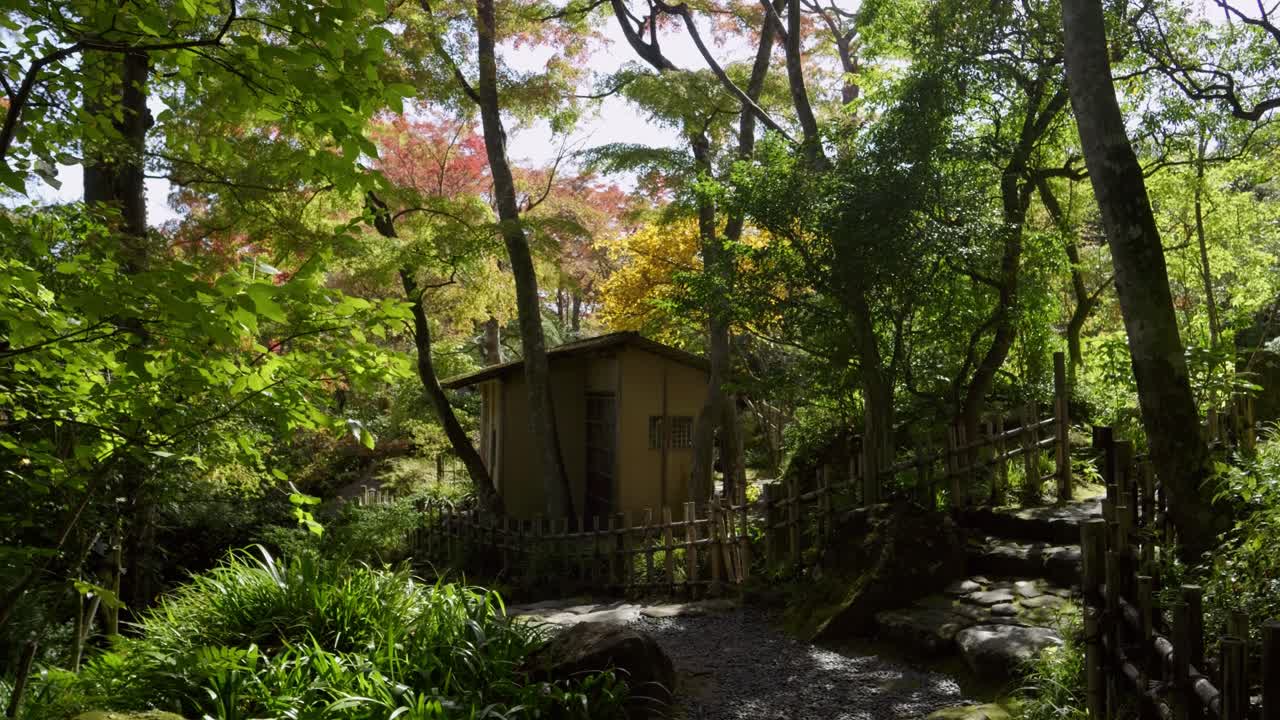 Tiny house inside Japanese landscape garden during vibrant fall color season