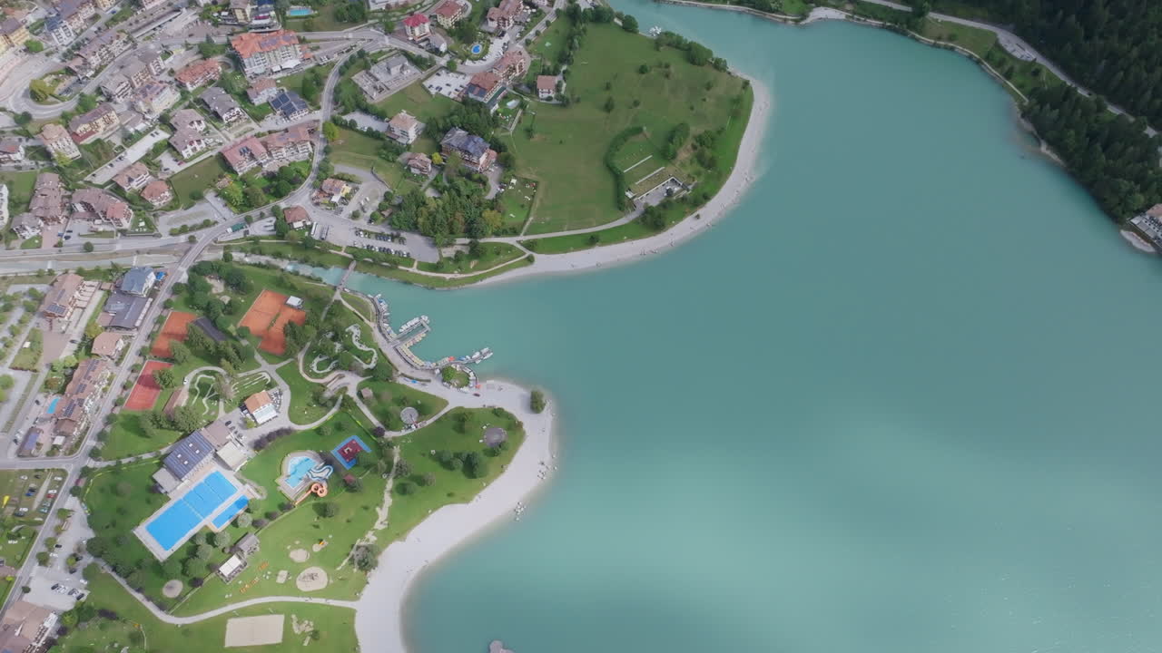 Wide aerial footage of the beach and buildings of the small Italian village of Molveno.
