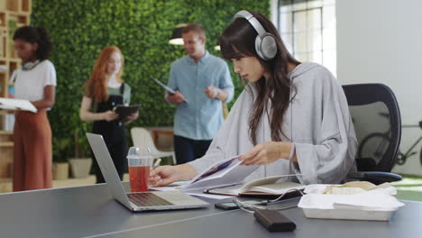 woman, laptop and notebook at tech startup writing