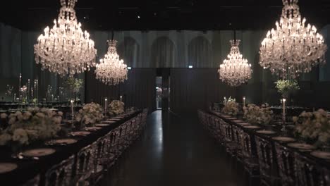 a gimbal forward movement wide shot of a wedding hall, luxury decoration, flower design, fancy interior, chandelier decorative lights, slow motion full hd video