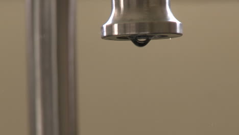 Close-up-of-water-dripping-fast-from-a-faucet-in-Oak-View-California