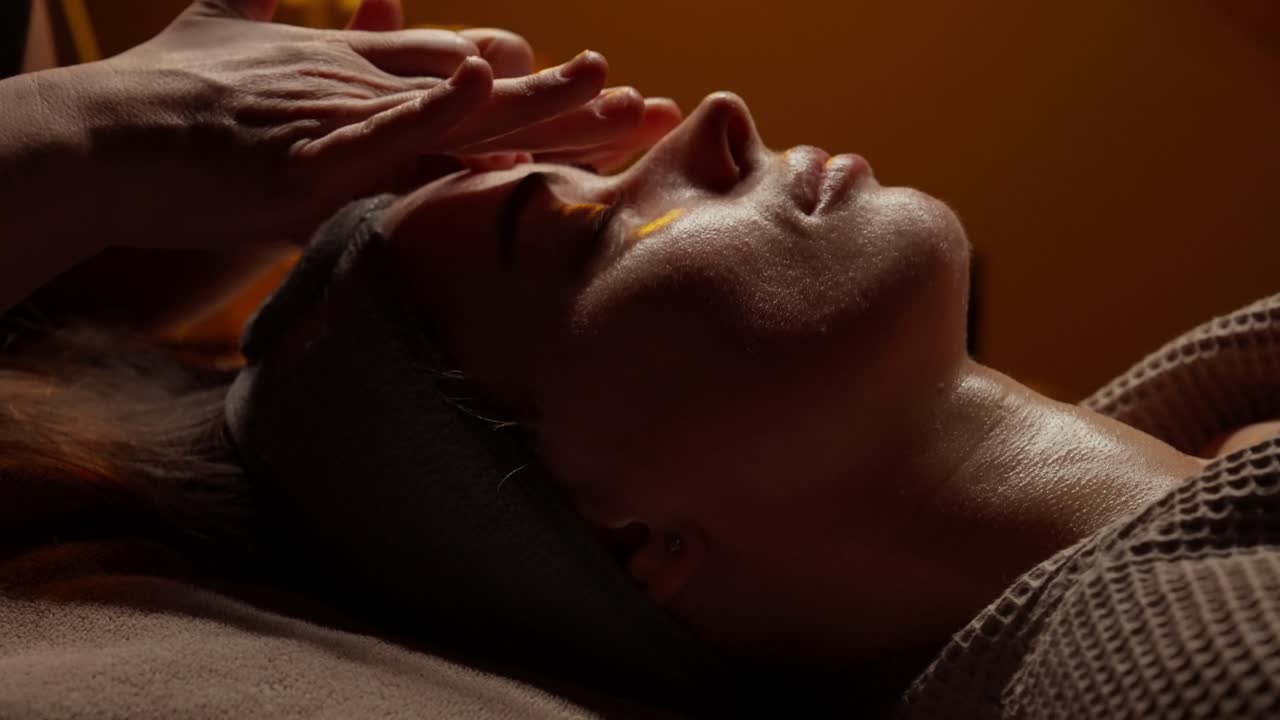 Nærbillede af kvinde, der får afslappende ansigtsmassage i spa