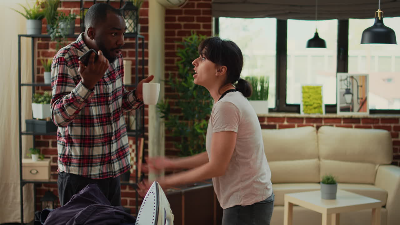 Angry girlfriend throwing shirt at boyfriend
