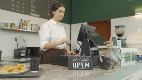 smiling happy young middle east woman waitress people wearing apron turning store from close to open sign, cafe cashier waitress at the coffee shop. people lifestyle. business service.