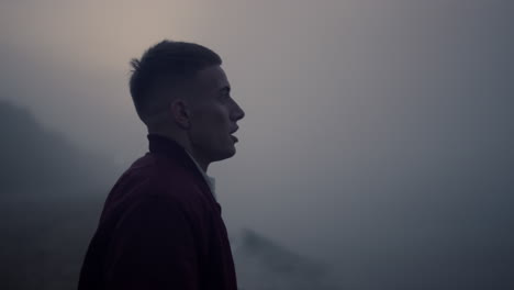 serious man walking on sea shore in morning fog. angry guy screaming on beach