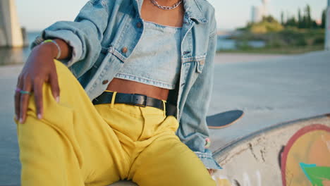 cool skater girl sitting skate park in stylish clothes close up.  model