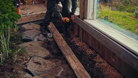 man constructing a greenhouse in norway - close up