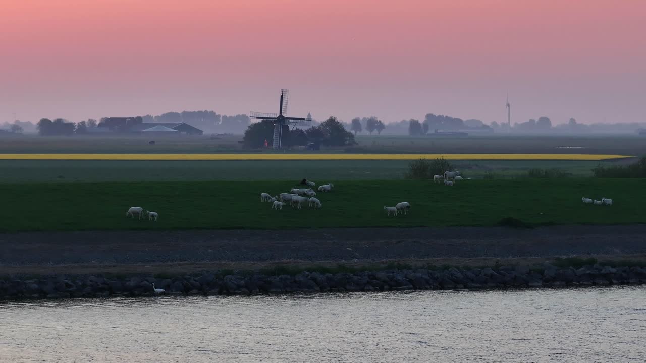 Flyfoto av Cornwerd med vindmølle, vindturbin, soloppgang, som viser et dramatisk landlig landskap i Nederland.