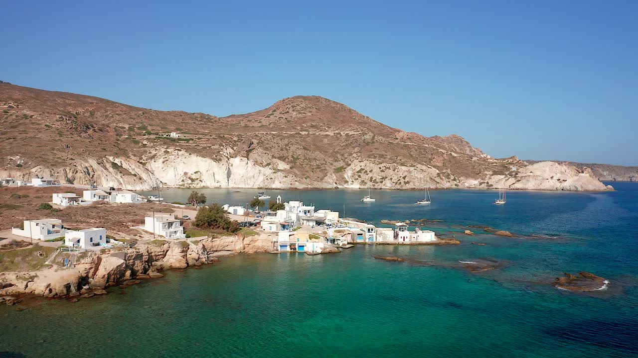 muñeca en la bahía de mandrakia, casas y barcos en el mar mediterráneo en la isla de milos