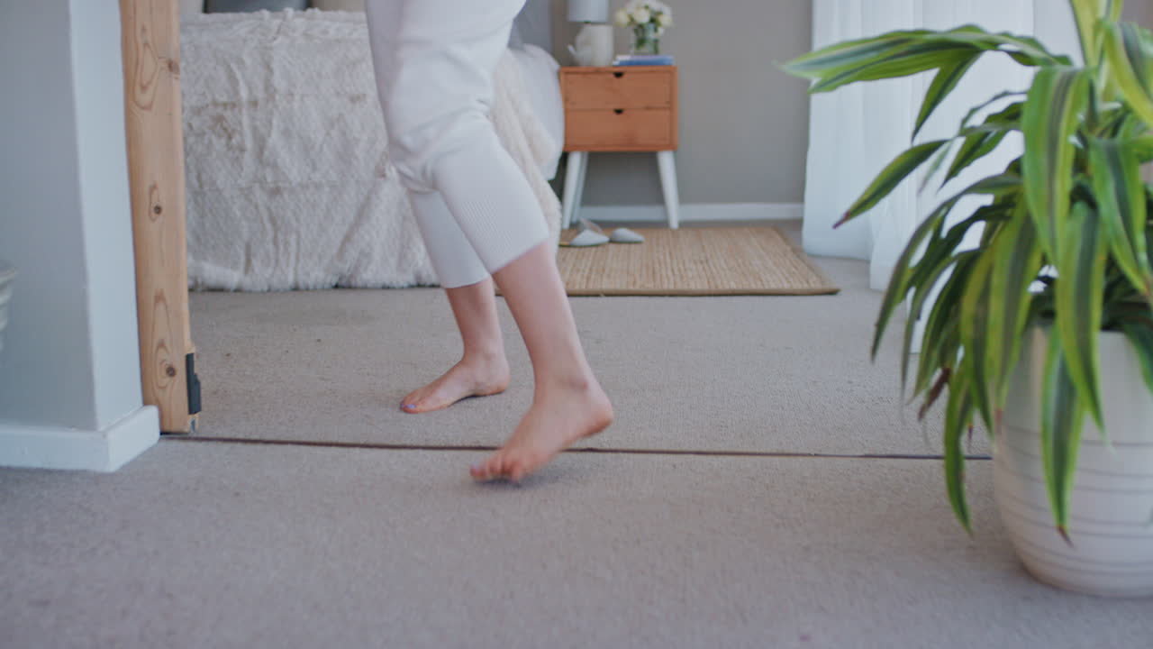 행복한 젊은 여성이 집에서 노래하고 즐겁게 성공적인 라이프 스타일을 축하하고 춤을 추고 카라오케 음악 엔터테인먼트를 즐기고 있습니다.