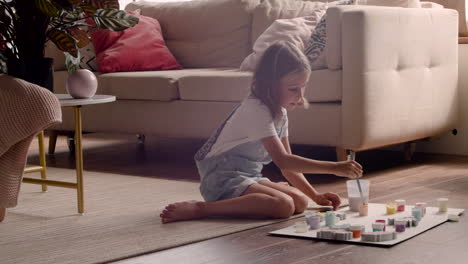 blonde girl sitting on the floor and painting animal pieces in living room 3