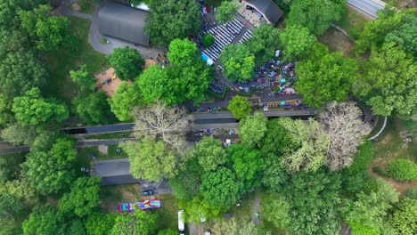 Aerial-view-of-an-outdoor-church-service-in-a-park-amphitheater,-choir-and-Sunday-devotional,-on-a-clear-summer-day