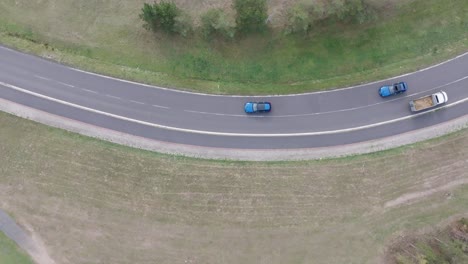 flying above similar blue cars drive on highway and reach intersection