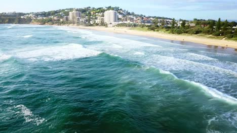 vista aérea tomada por un dron volando sobre las olas del mar golpeando la playa
