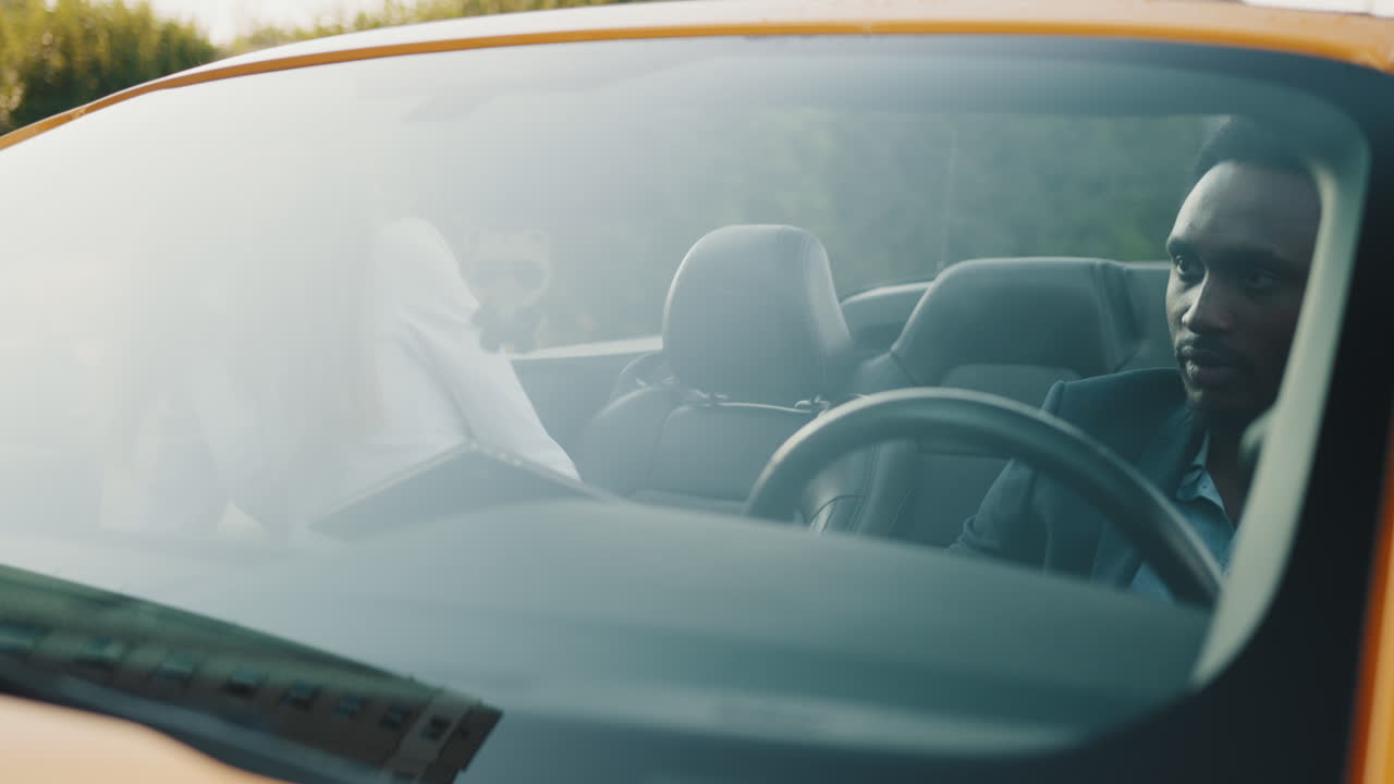 커플 이 컨버터블 자동차 를 타고 즐기고 있다