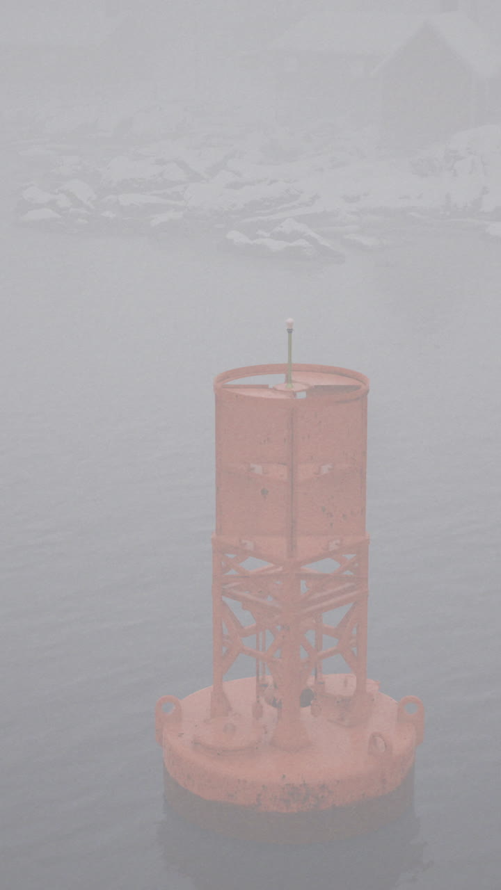Buoy stands in foggy waters near icy landscape at dawn