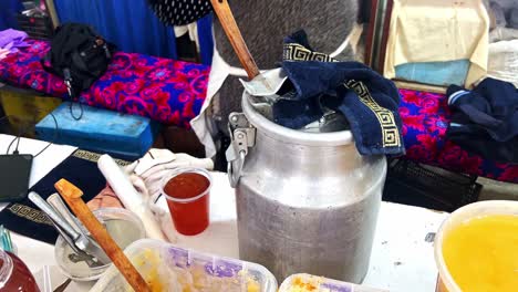 pure-natural-honey-transferring-into-a-plastic-bottle-in-the-market,-world-oldest-Silk-Road-Market-in-Samarkand-District,-Siab-Bazaar,-largest-bazaar-in-Samarkand,-domestic-and-foreign-tourists